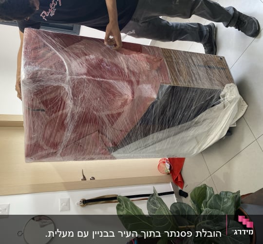 הובלת פסנתר בתוך העיר בבניין עם מעלית.